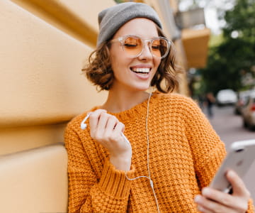 a girl holding a phone and looking at its screen